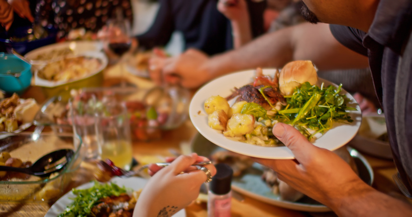 Man Serving Himself at Friendsgiving Potluck Dinner